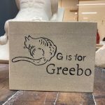 Small pet memorial, carved in stone, with the name Greebo and a relief carving of a cat